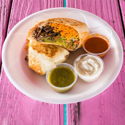 Grilled burrito cut in half with salsas
